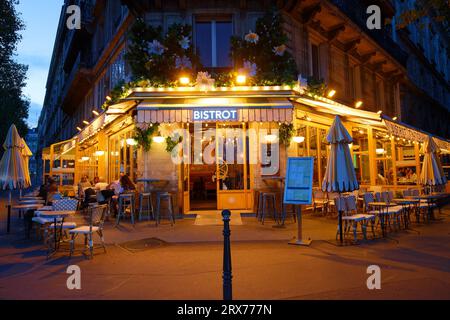 PARIS, FRANCE - September 20 ,2023 : Typical Parisian cafe Marguerite decorated with flowers at night located next town hall of Paris, France. Stock Photo