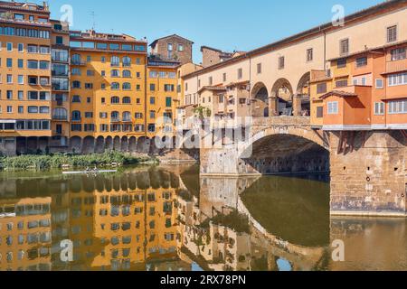 Florence, Italy - 15 July 2023: Ponte Vecchio with tourists and people in canoes paddling in the Arno river Stock Photo