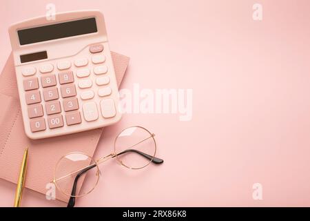 Calculator, glasses and notepad on a pink background. Place for text. High quality photo Stock Photo