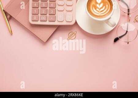 Calculator, a cup of coffee with a beautiful pattern and a notepad on a pink background. Place for text. High quality photo Stock Photo