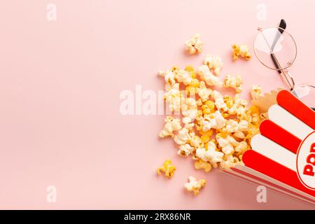 Popcorn is scattered over a pink background. Empty space for text. High quality photo Stock Photo
