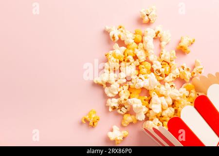 Popcorn is scattered over a pink background. Empty space for text. High quality photo Stock Photo
