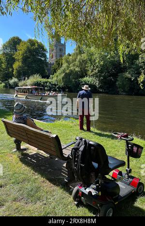 A man stands on the bank of the River Avon watching a boat pass by on a summers day in Stratford upon Avon. September 2023. Stock Photo