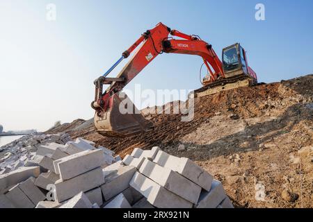 Luannan County, China - November 23, 2022: Engineering vehicles are arranging slope protection on the bank of the canal, Luannan County, Hebei Provinc Stock Photo