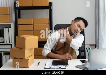 A businessman or professional person sitting stressed at work in an indoor workplaceat office job use computer laptop desk employee stressed problem c Stock Photo