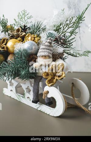 Christmas composition in with spruce, elf for table decoration. Green bunches with bobbles in beautiful packaging, assembled by a florist. Floristic Stock Photo