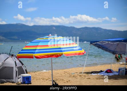 Beach umbrellas and tents at Pope Beach on a sunny summer day. South Lake Tahoe. Stock Photo