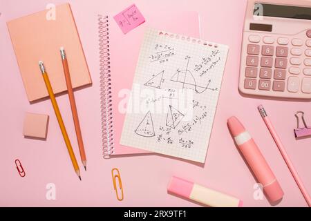 On a pink background, pink school supplies, a calculator, cheat sheets. High quality photo Stock Photo
