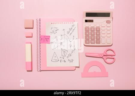 On a pink background, pink school supplies, a calculator, cheat sheets. High quality photo Stock Photo