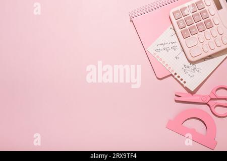 On a pink background, pink school supplies, a calculator, cheat sheets. High quality photo Stock Photo