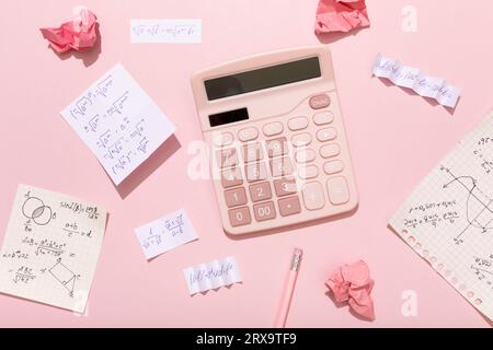 On a pink background, pink school supplies, a calculator, cheat sheets. High quality photo Stock Photo