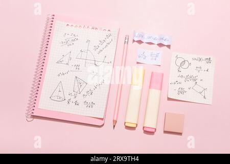 On a pink background, pink school supplies, a calculator, cheat sheets. High quality photo Stock Photo