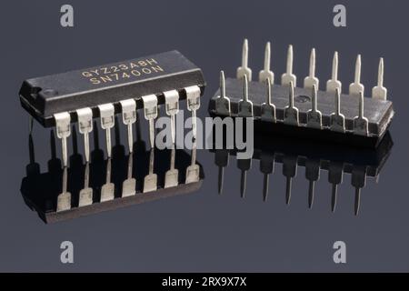 Two 7400 logic chip on a dark background with reflection. Macro photograph Stock Photo