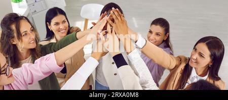 Group of cheerful young woman doing high five together Stock Photo