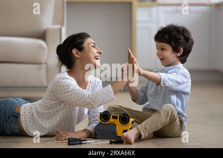 Excited Indian mother with 5s son repairing toy car Stock Photo