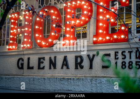 Panning shot showing the signboard of Glenary's Hope showing the famous landmark cafe bakery that is a must visit for tourists on mall road in Stock Photo