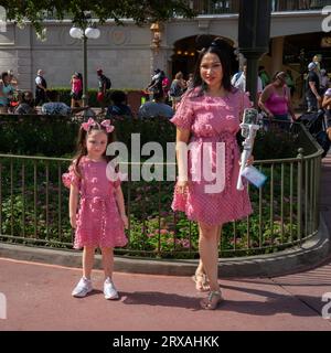Orlando, USA - July 25th, 2023: A mother and her daughter in matching outfits in a visit to Disney's Magic Kingdom. Stock Photo
