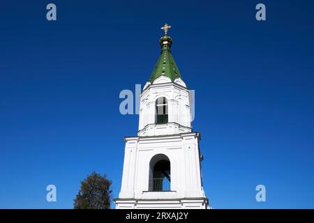 White bell tower of an Orthodox church against a blue sky without clouds Stock Photo