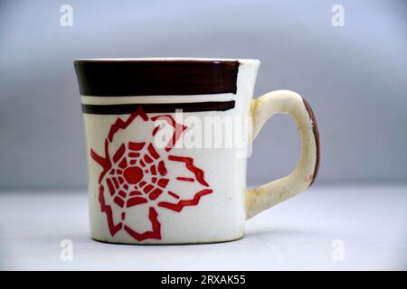 White ceramic mug with teabag label. Isolated on a white and red Stock Photo