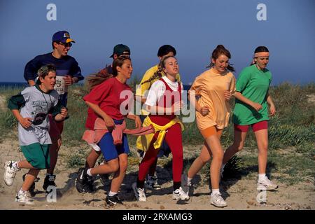 Young people jogging on the beach, group Stock Photo