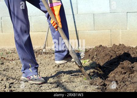 Worker digging soil with shovel outdoors, closeup. Gardening tool Stock ...