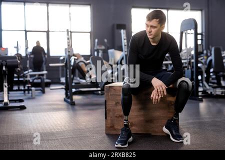 young thoughtful exhausted upset athlete looking sideways, full length photo. copy space. depression, tiredness Stock Photo