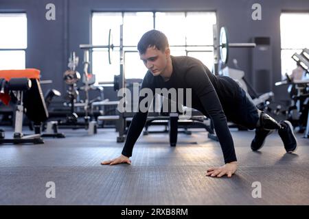 never give up, motivated gorgeous man doing press-up exercises at gym, blurred background, willpower, endurance Stock Photo