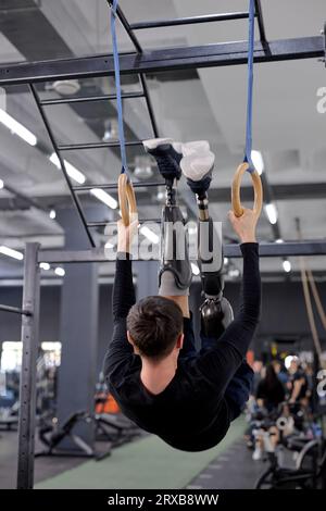 unbelievable workout with gymnastic rings. ambitious active guy raising, lifting his body while training with gymnastic rings. motivation. Stock Photo