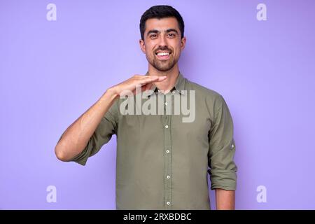 smiling happy man with raised arm using gesture to communicate talk chat with friends, close up portrait isolated blue background studio shot Stock Photo