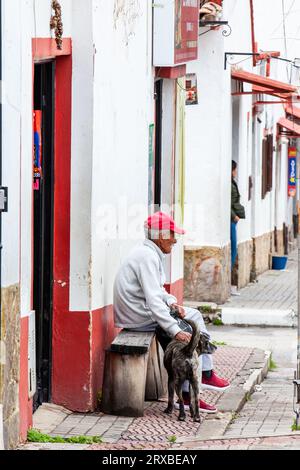 Tibasosa, Boyaca, Colombia - August 9th 2023. Senior man and his dog at the small town of Tibasosa located in the Boyaca department in Colombia Stock Photo