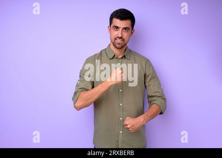 Young deaf mute man saying the word work, job using sign language on blue background, close up portrait isolated building house concept Stock Photo