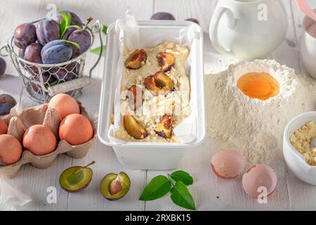 Preparation for sweet plum cake with fruits and crumble. Ingredients for homemade plum cake. Stock Photo