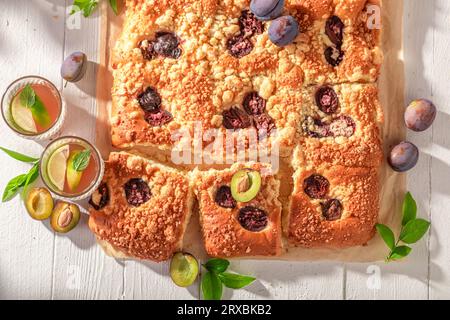 Homemade plum yeast cake served with fresh lemonade. Plum yeast cake with crumble and berries. Stock Photo