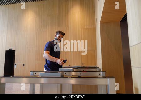 Happy successful businessman or entrepreneur enters office going through security gates doorway Stock Photo