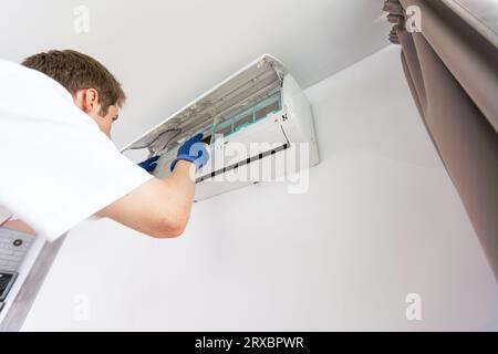 technician service removing air filter of the air conditioner for cleaning. Stock Photo