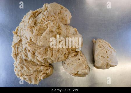 The dough for cold water crust pastry is being prepared on a metal table. Stock Photo