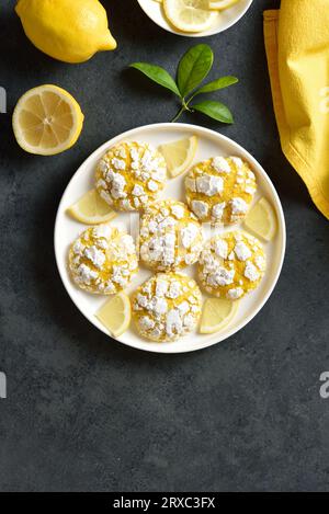Lemon crinkle cookies on plate over dark stone background with copy space. Top view, flat lay Stock Photo