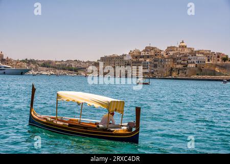 Luzzu, a typical Maltese boat and in the background Vittoriosa in Malta Stock Photo