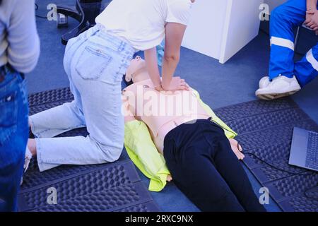 Woman doing resuscitation to a training dummy in the emergency room Stock Photo