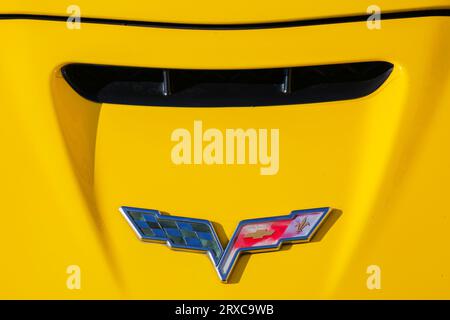 uzhgorod, ukraine - 31 oct 2021: shabby chevrolet corvette logo on a yellow hood. outdoor close up Stock Photo