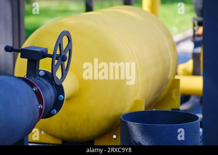 Fire extinguishing module with heat flow on gas pipes. Yellow gas pipeline with valve on the background of green grass Stock Photo