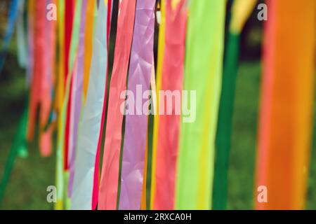 A close-up photograph captures the beauty of multicolored ribbons hanging gracefully outdoors. Stock Photo