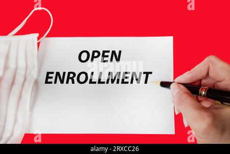 Open registration. Text and woman's hand holding pen on notepad Stock Photo