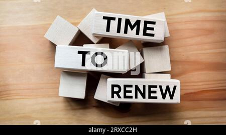 The word RENEWAL TIME is written on wooden blocks on a brown table. Stock Photo