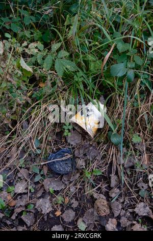 A McDonald's take away Coffee cup discarded on a countryside path in the New Forest Hampshire showing signs of  degrading. Stock Photo