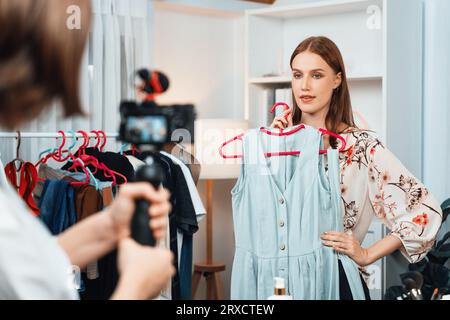 Woman influencer shoot live streaming vlog video review clothes utmost social media or blog. Happy young girl with apparel studio lighting for Stock Photo