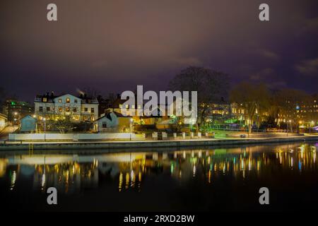 Scenic view of lake by illuminated buildings against sky at night Stock Photo