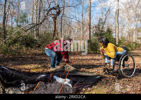 A couple sets up a tent at a campground. Both are disabled but love the outdoors. Stock Photo