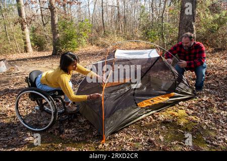 A couple sets up a tent at a campground. Both are disabled but love the outdoors. Stock Photo