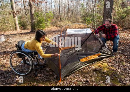 A couple sets up a tent at a campground. Both are disabled but love the outdoors. Stock Photo